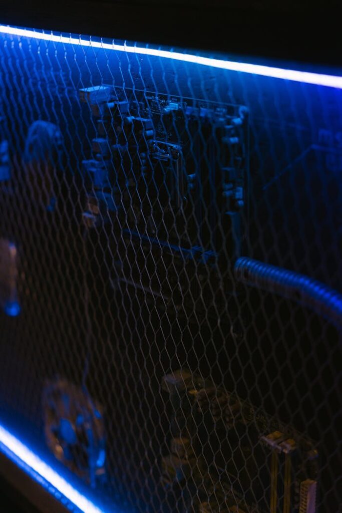 Detailed view of a computer setup with neon lighting highlighting its internal components.