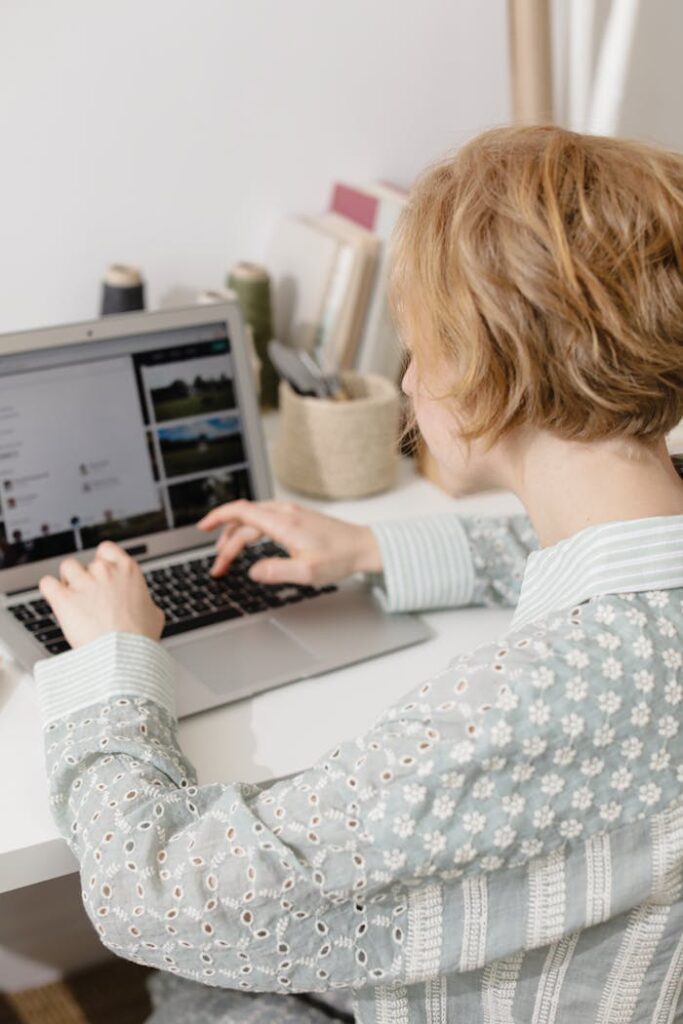 Woman using laptop at home desk for remote work, embodying digital nomad lifestyle.